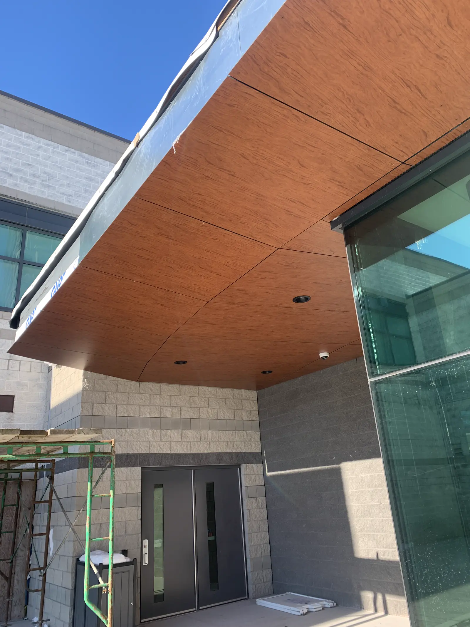 Completed wood-finish soffit and canopy over a building entrance